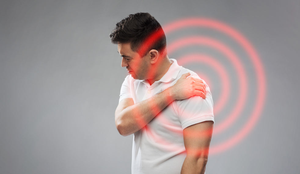 people, healthcare and problem concept - unhappy man suffering from pain in shoulder over gray background